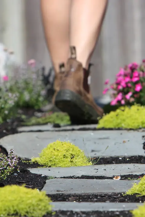 Person walking on a stone pathway in a garden